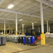 pictured: an EnviroServe waste disposal facility featuring barrels and a forklift