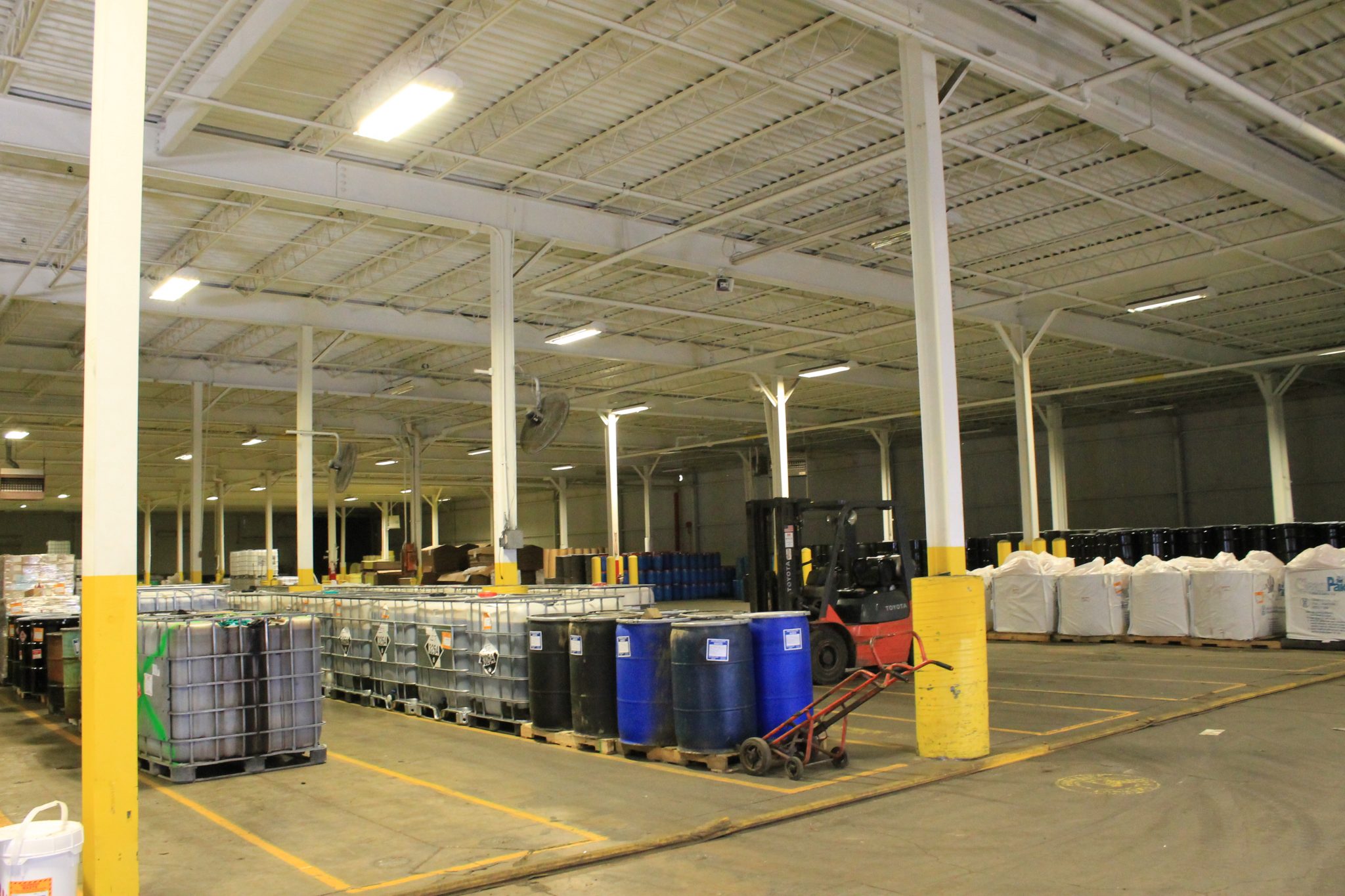 pictured: an EnviroServe waste disposal facility featuring barrels and a forklift