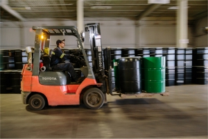 pictured: an EnviroServe team member operates a forklift to move barrels of hazardous waste