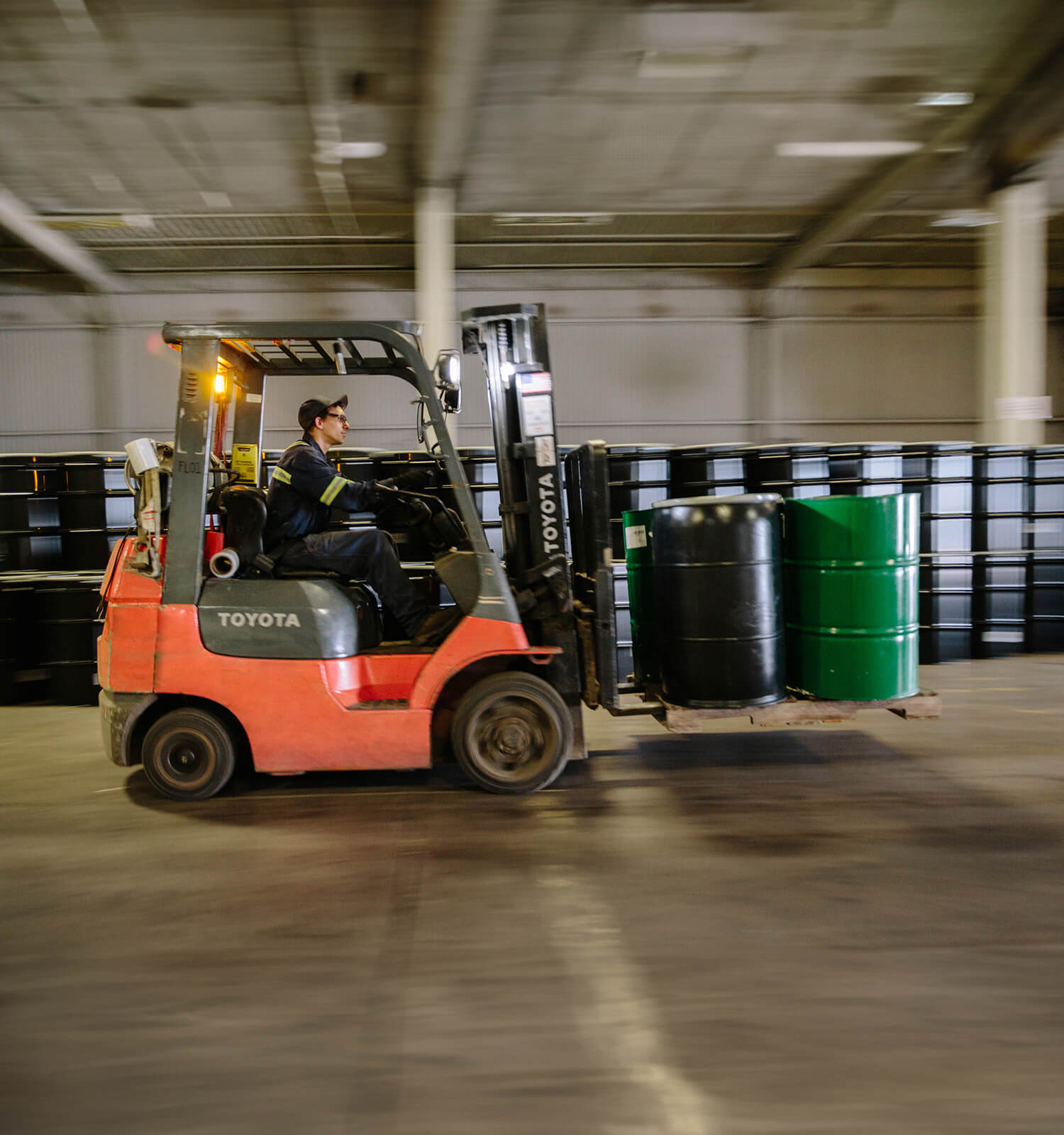 pictured: an EnviroServe forklift operator speeds forward with two barrels of hazardous waste