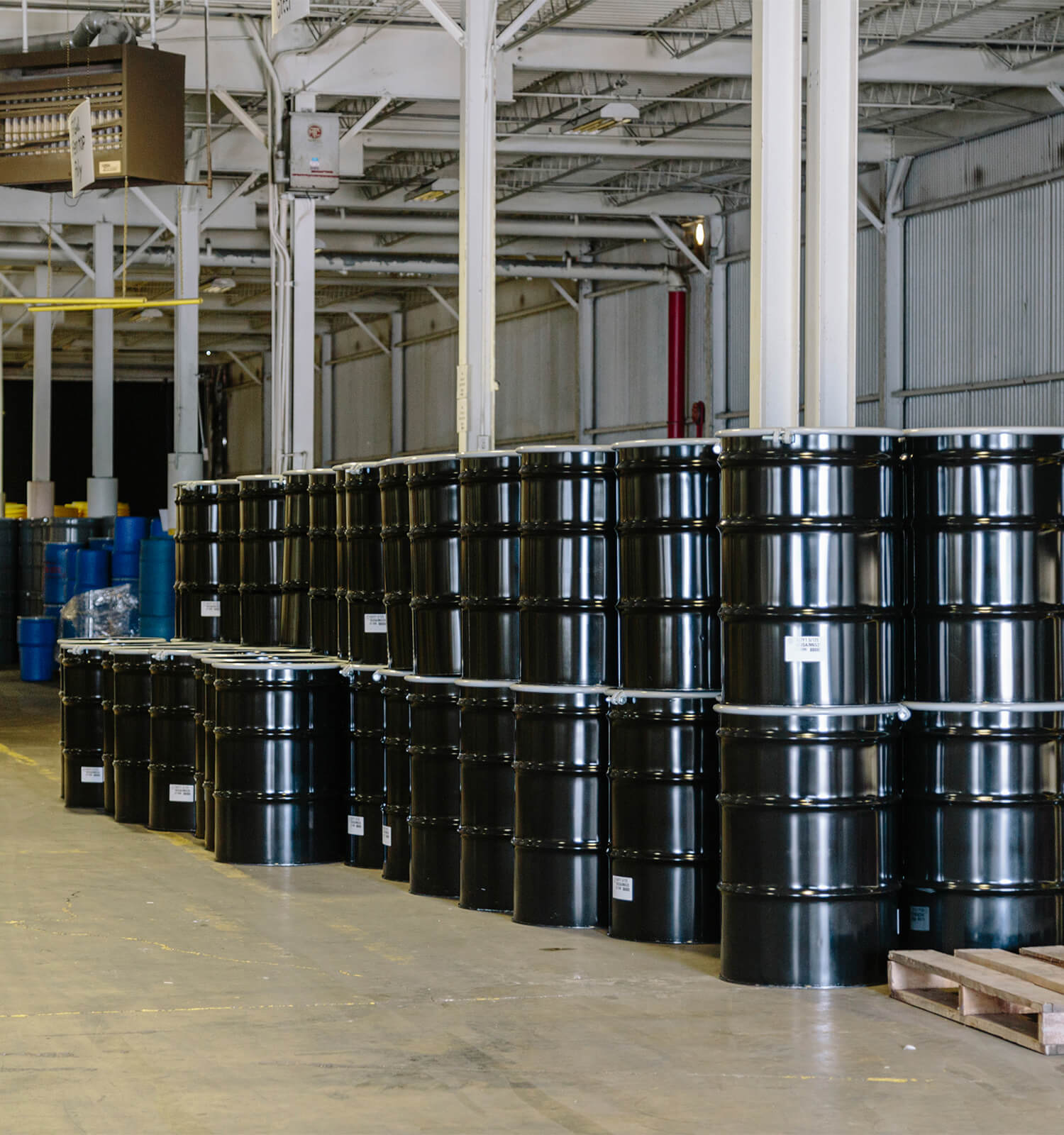 pictured: a warehouse with clean stacks of barrels filled with safely-contained hazardous waste materials