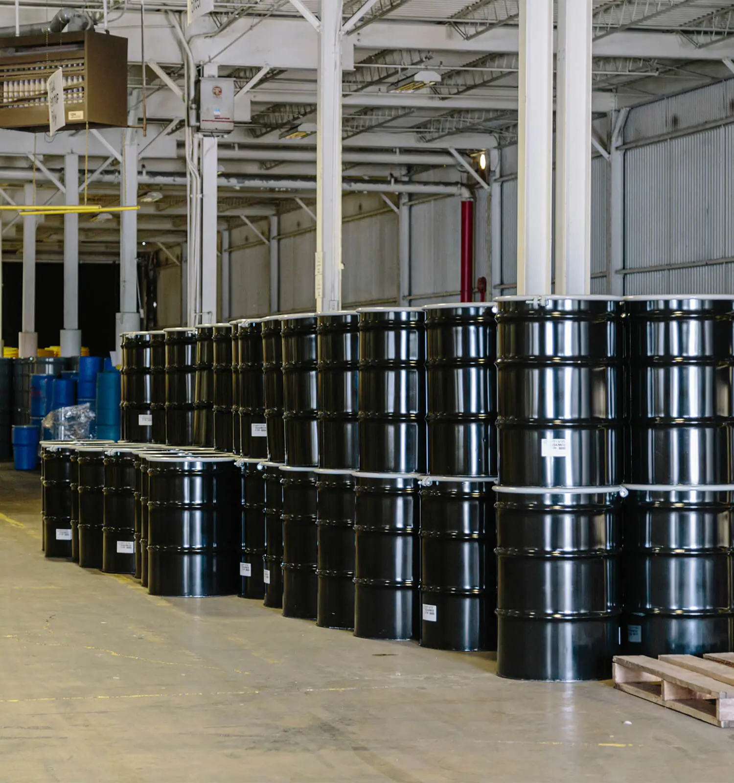 pictured: a warehouse with clean stacks of barrels filled with safely-contained hazardous waste materials